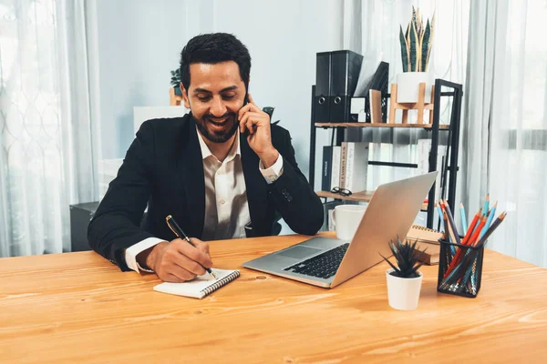 Delighted business owner working at a desk in a modern private office